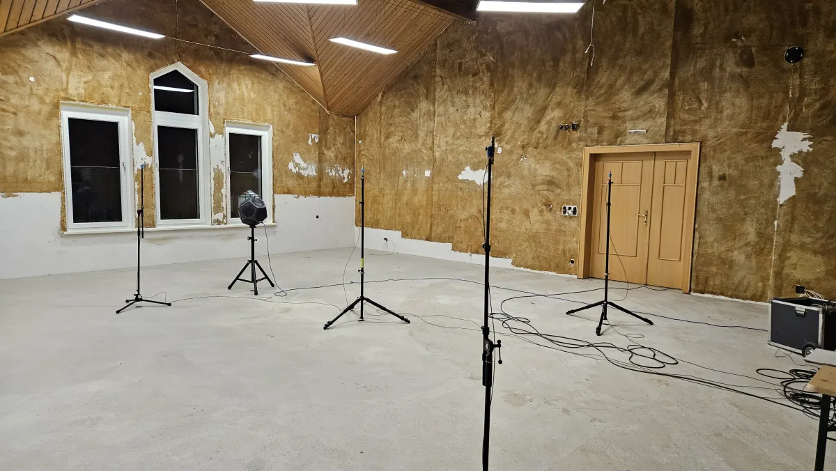Empty room with measurement microphones on stands.